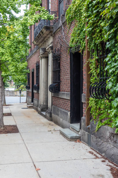 istock Sidewalk alongside residential building with bowed wrought iron grates over ground floor windows 1177126372