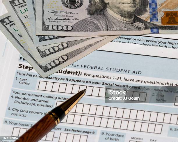 Student Financial Aid Application Forms For College Tuition Loans And Grants With Onehundred Dollar Bills And Ballpoint Pen Stock Photo - Download Image Now