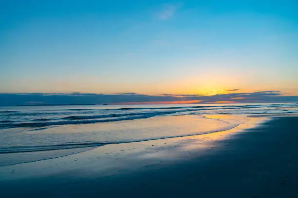Photo of Ocean beach as sun is on horizon