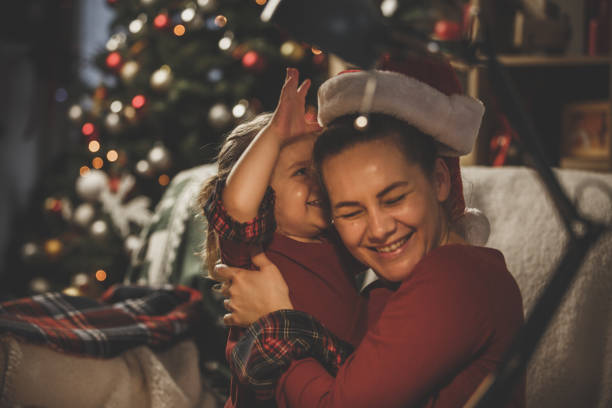 istock Girl putting Santa hat on mother's head 1177130180