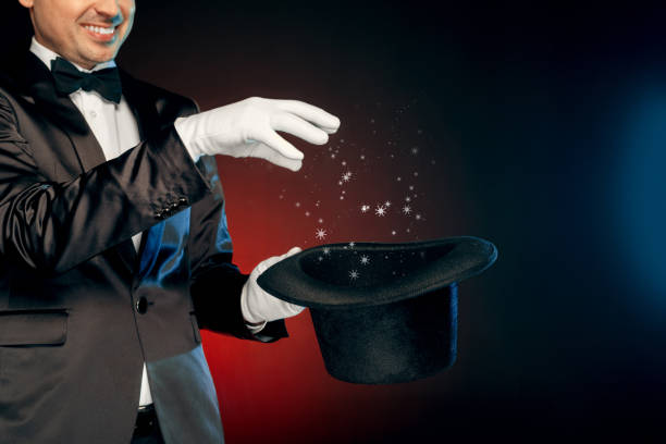 istock Professional Occupation. Showman in suit and gloves standing isolated on wall making tricks with hat close-up smiling cheerful 1177131116