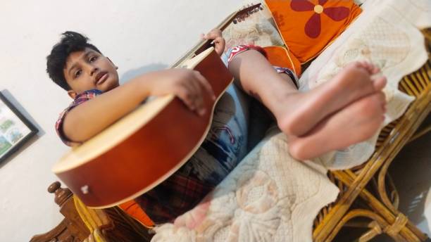istock A Barefoot Young Boy in India Practices his Guitar in his Bedroom 1177141156