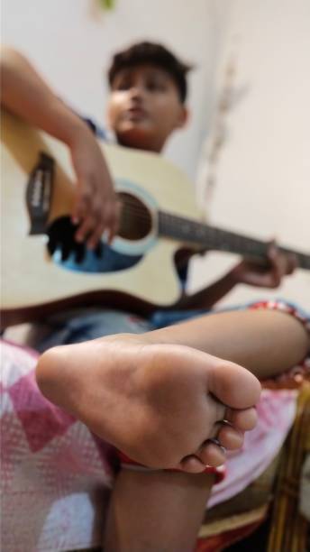 istock A Barefoot Young Boy in India Practices his Guitar in his Bedroom 1177141188