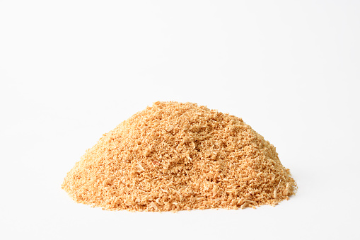 Close-up and pile of sawdust on white background.