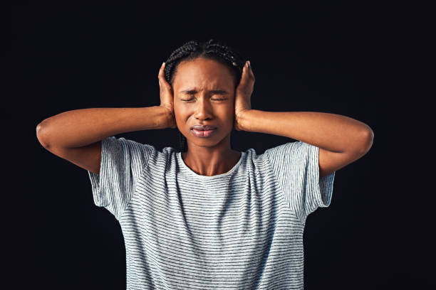 I don't want to know! Studio shot of a young woman covering her ears against a black background hands covering ears stock pictures, royalty-free photos & images