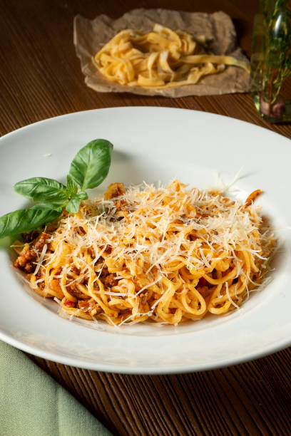 Bolognese pasta with red sauce, parmesan and minced meat. Italian spaghetti with meat in a white plate on a wooden background. Bolognese pasta with red sauce, parmesan and minced meat. Italian spaghetti with meat in a white plate on a wooden background. Slective Focus stock pictures, royalty-free photos & images