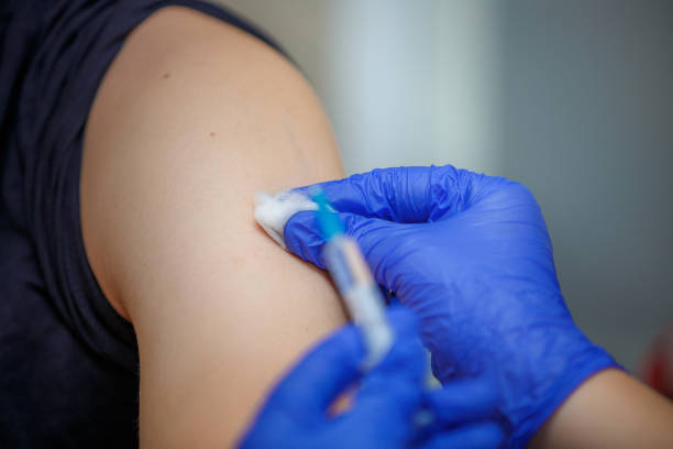 seringa com a medicina nas mãos de um doutor em luvas azuis. - syringe vaccination human hand medical procedure - fotografias e filmes do acervo