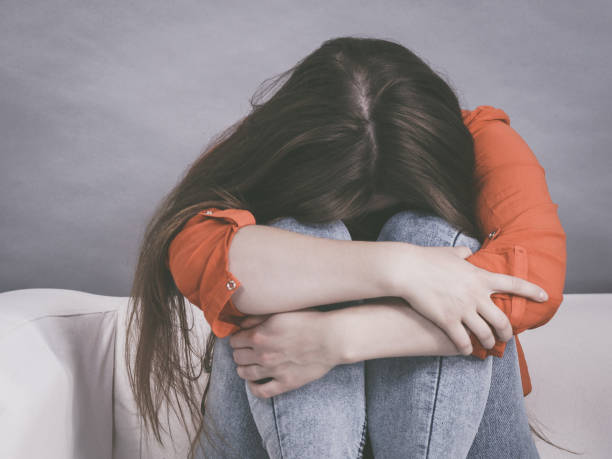 istock Worried woman sitting on sofa 1177166450