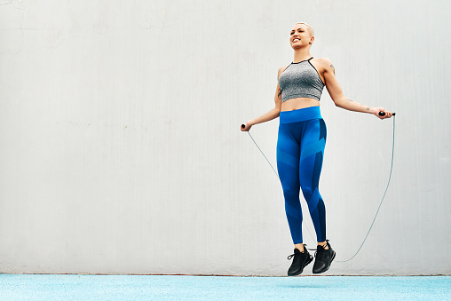 Full length shot of an attractive young athlete using a skipping rope during an outdoor training session