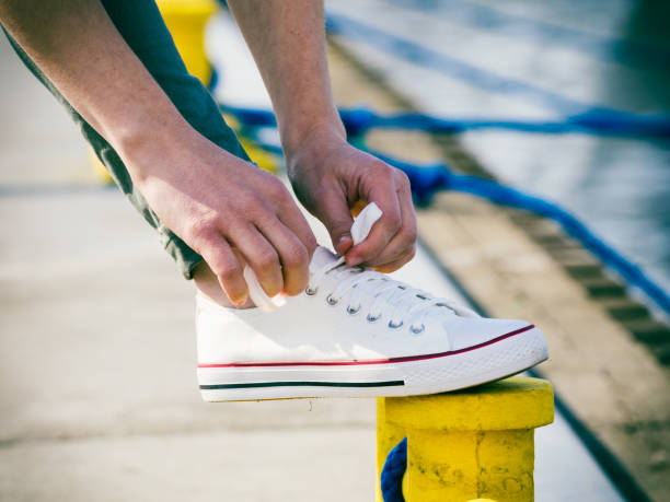 istock Woman tying shoes, white sneakers 1177170640