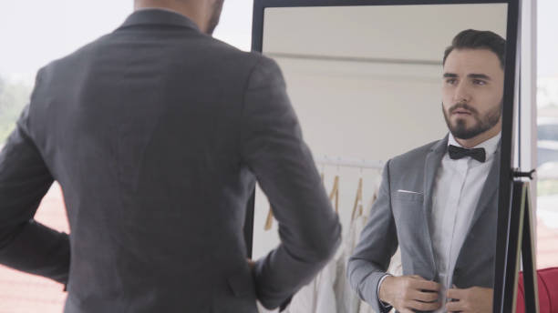 istock Man in formal suit getting dressed in dressing room for work or wedding. 1177173607