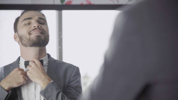 istock Man in formal suit getting dressed in dressing room for work or wedding. 1177173608