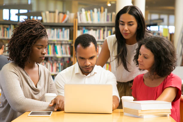istock Serious mature students working with laptop at public library 1177174548