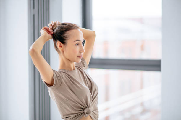 istock young awesome woman ddoing a hairbun before yoga classes 1177174784