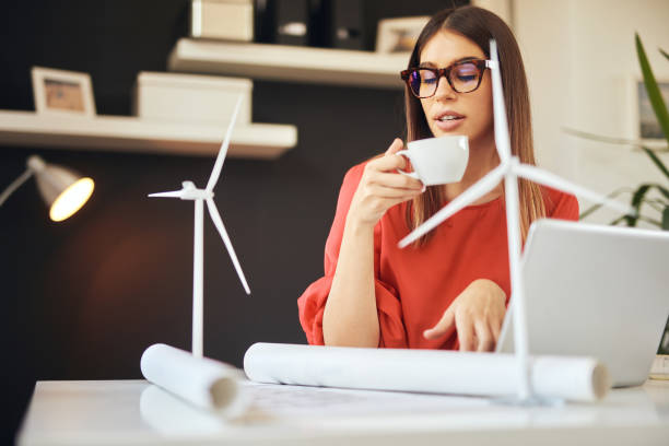 istock Businesswoman drinking coffee and looking at plans. Sustainable development concept. 1177175136