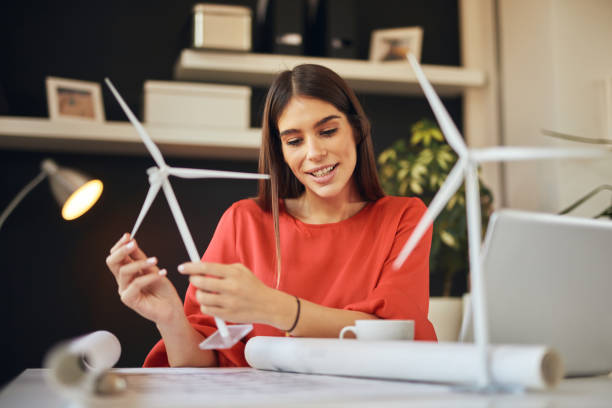 istock Businesswoman holding windmillmodel and looking at plan. Sustainable development concept. 1177175819