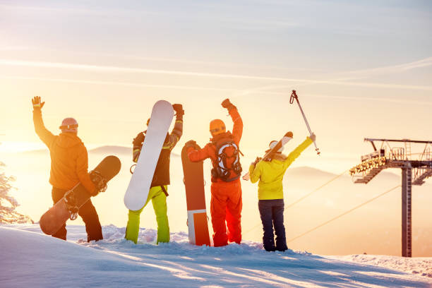 sciatori felici e snowboarder in cima al tramonto - snowboarding friendship snow winter foto e immagini stock