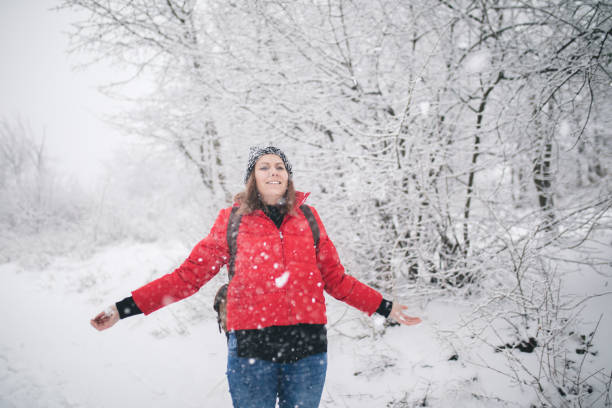 istock Woman with a backpack walking through winter forest. 1177185713