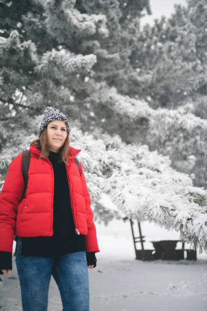 istock Woman with a backpack walking through winter forest. 1177186285