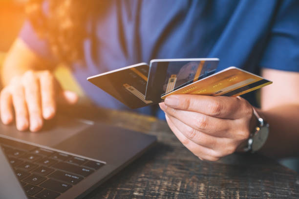 istock a business woman holding credit cards while using laptop computer 1177187507