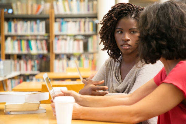 istock Thoughtful women discussing new project at library 1177188175