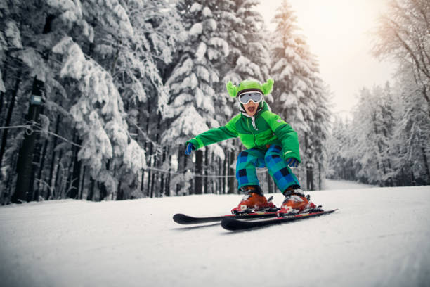 niño esquiando rápido en un hermoso día de invierno - skiing snow skiing helmet fun fotografías e imágenes de stock