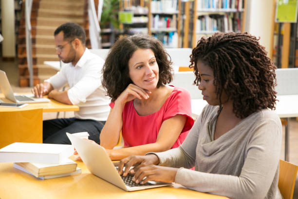 istock Cheerful women working with laptop at public library 1177190218