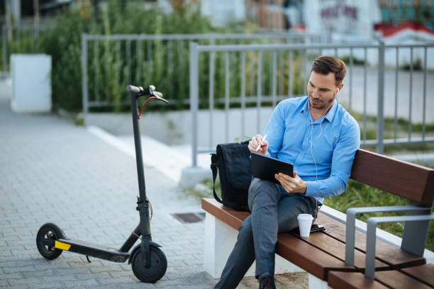 istock Businessman using digital tablet in the city park after scooter riding 1177190621