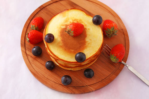 Fluffy and delicious pancakes on a wooden plate
