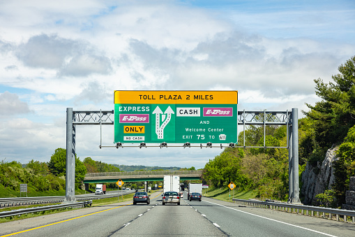 Pennsylvania highway, USA. May 6, 2019: Toll plaza information road signs billboard on the highway, cloudy sky