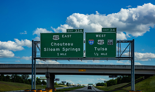 Oklahoma highway, USA. May 29, 2019: Road sign, informative, green color billboard on the highway, blue cloudy sky