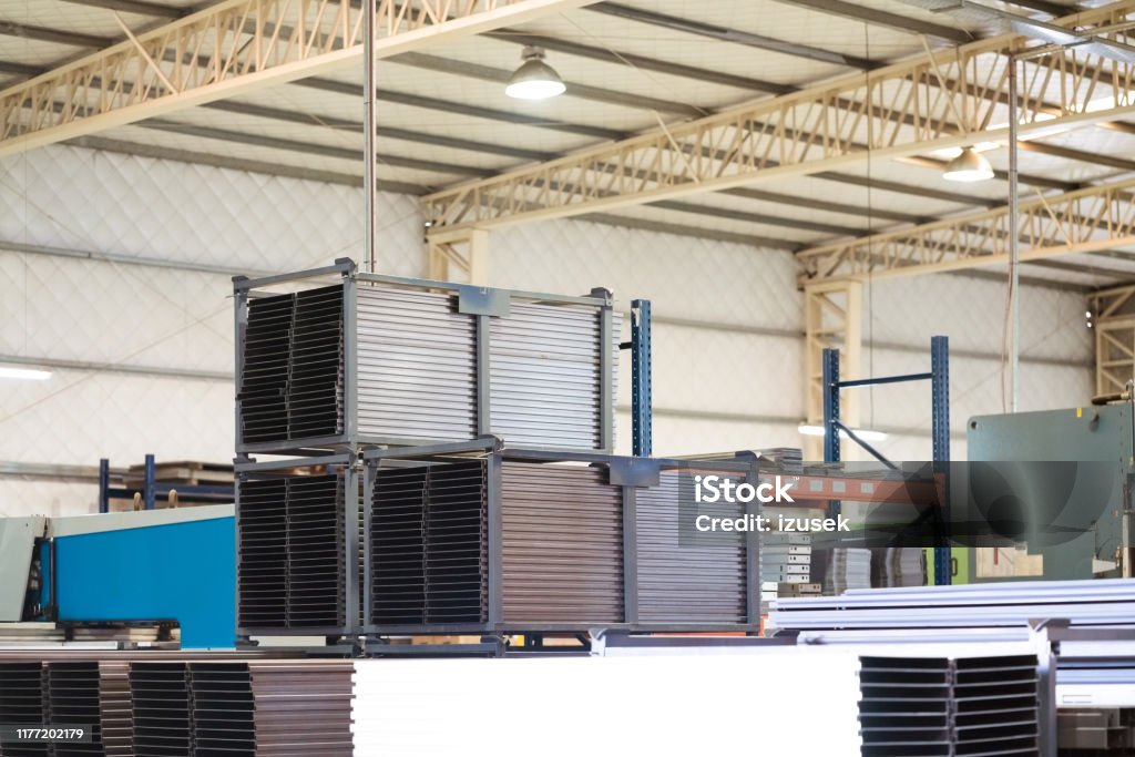Stack of metallic sheets on rack in industry Stack of metallic sheets on rack. Low angle view of arranged machine parts. These are in manufacturing industry. Absence Stock Photo