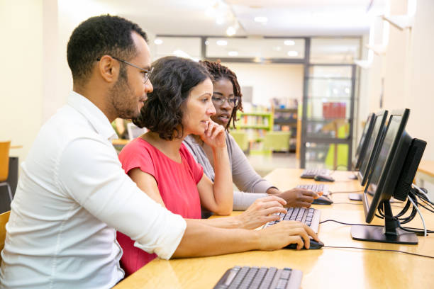 istock Diverse adult college mates working together in computer class 1177202595