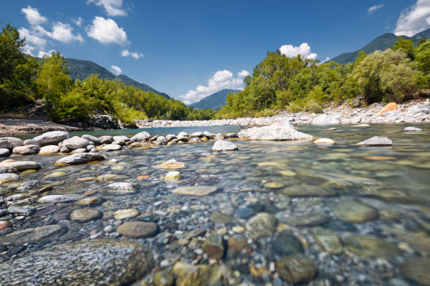 Long exposure with strong 64x nd-filter picture at daytime. Photography of the flowing river Maggia in Switzerland. Wilderness and lonely landscape that can be explored with outdoor activities.