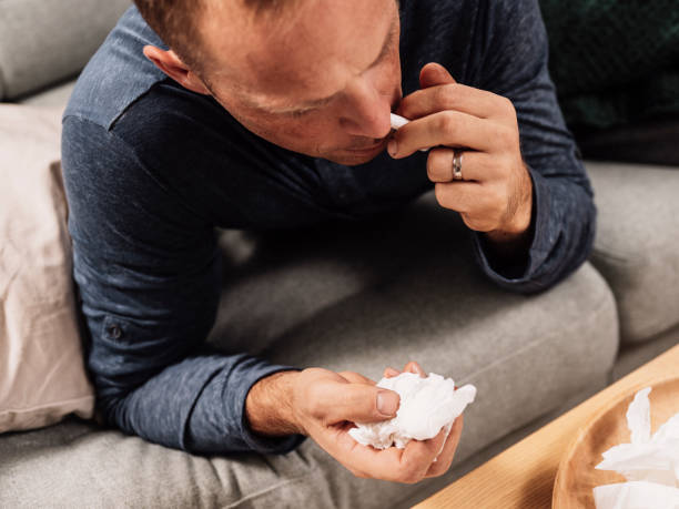istock Sick man having a flu cold applaying nasal spray 1177209967