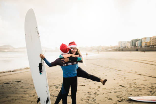 istock Two surf instructors couple on the beach with their surfboard 1177211485