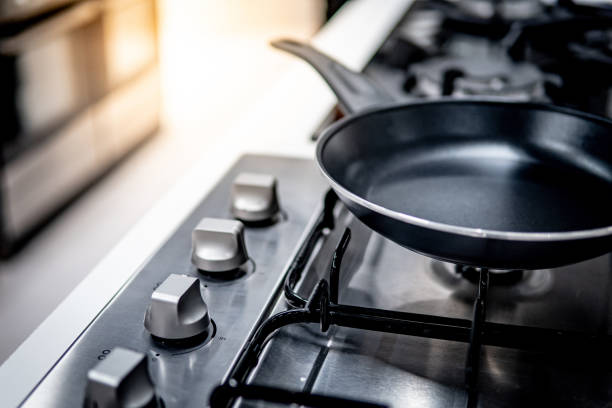 Teflon pan on gas stove in the kitchen Black Teflon pan on modern gas stove in the kitchen. Cookware or kitchenware concepts polytetrafluoroethylene photos stock pictures, royalty-free photos & images