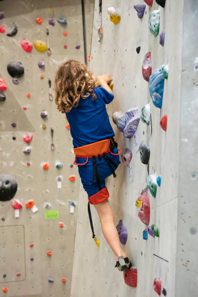 istock Young boy is climbing an indoor climbing wall 1177216446