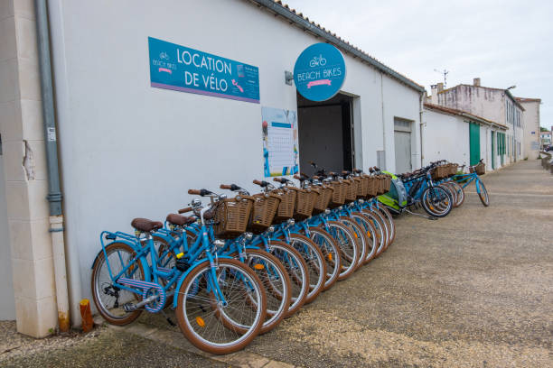 Bike renting on the street of La Flotte village on Ile de Re island in France. Isle of Re, France - May 09, 2019: Bike renting on the street of La Flotte village on Ile de Re island in France. flotte stock pictures, royalty-free photos & images