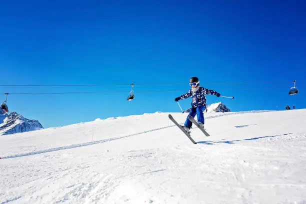 Photo of Happy people, children and adults, skiing on a sunny day in Tyrol mountains