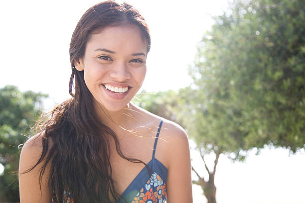 cheerful woman backlit by the sun - spaghettibandjes stockfoto's en -beelden