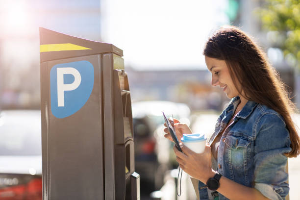 Young Woman Using Parking Machine Portrait of beautiful young woman in urban area parking meter stock pictures, royalty-free photos & images