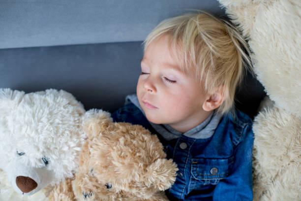 istock Blond toddler boy, sleeping with many teddy bears in the afternoon 1177222969