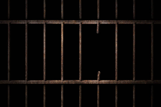istock Prison cell with broken old prison bars on black, way out to freedom 1177223023