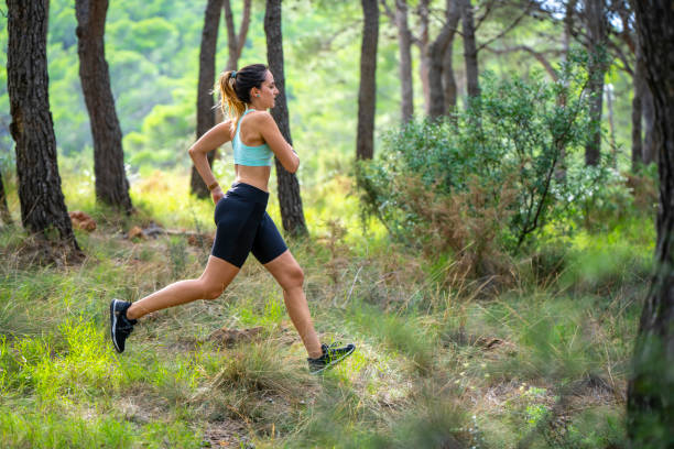 istock Young woman running in forest mountain 1177226329