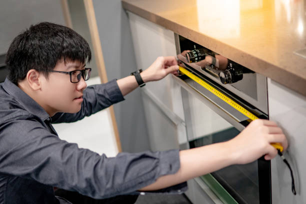 istock Asian man using tape measure on oven 1177226945
