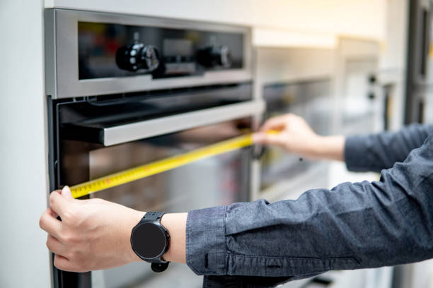 istock Male hand using tape measure on oven 1177227031