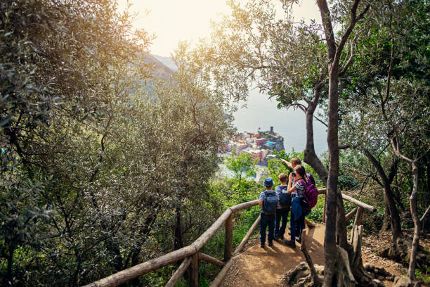 Tourist family hiking in Cinque Terre, Italy Family hiking in trails of Cinque Terre - a UNESCO World Heritage Site. The family is looking from the distance at the beautiful city of Vernazza.
\Nikon D850 liguria photos stock pictures, royalty-free photos & images