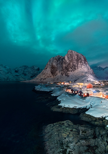 Beautiful moment of Northern Light above the beautiful mountains behind the village Hamnøy on the Lofoten in Norway. During the winter months the chance of seeing Northern Lights on the Lofoten is qui