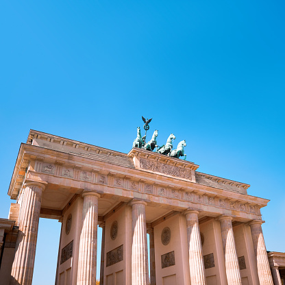 Brandenburg Gate (Brandenburger Tor) in Berlin, Germany, on a bright day with blue sky. Square composition with copy-space.